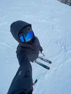 a person on skis in the snow wearing goggles and holding their ski poles