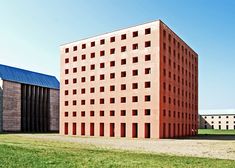 two large brick buildings sitting next to each other on top of a grass covered field