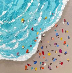 an aerial view of the ocean and beach with colorful objects floating in the water, from above