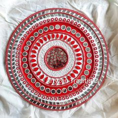 a red and white plate sitting on top of a bed covered in paper machs