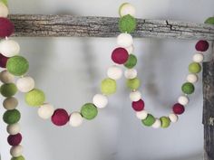 a close up of a wooden object with felt balls on it