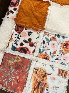 a patchwork quilt with an animal and flowers pattern on the front is laying on a wooden floor