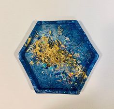 a blue plate with gold flecks on it sitting on a white table top