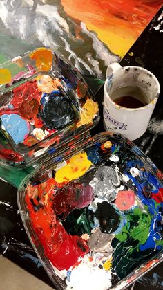 a cup of coffee sitting on top of a table covered in paint