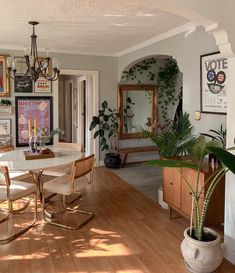 the dining room table is surrounded by chairs and potted plants