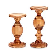 two gold colored candlesticks sitting next to each other