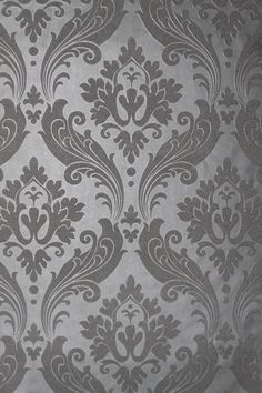 an old fashioned wallpaper pattern with grey and white designs on the back half of it