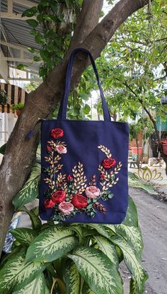 a blue bag hanging from a tree with flowers on it