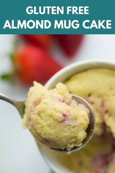 a spoon full of gluten free almond mug cake with strawberries in the background