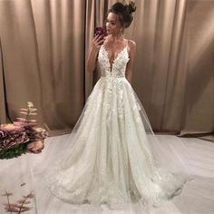 a woman taking a selfie while wearing a wedding dress in front of a mirror