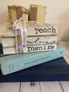 three books stacked on top of each other and tied with a ribbon in front of them