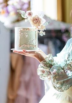 a woman holding a cake with flowers on it