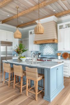 a kitchen with blue and white cabinets, wood flooring and wooden beams on the ceiling