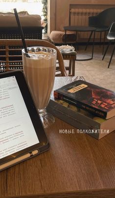 a tablet computer sitting on top of a wooden table next to a cup of coffee