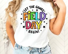 a woman wearing a t - shirt that says, let the games field day begin