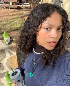 a girl with curly hair holding a water bottle