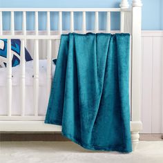 a baby crib with a blue blanket on it