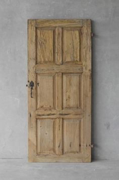 an old wooden door is shown against a gray wall with no one in the room