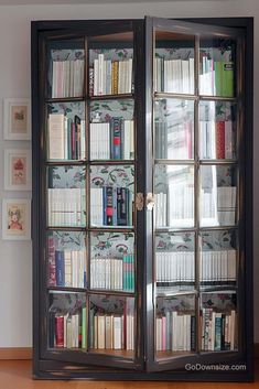 a book case filled with lots of books on top of a wooden floor