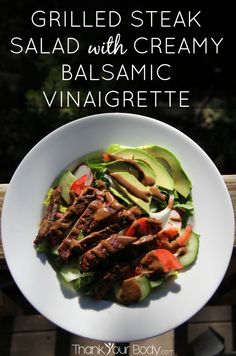 grilled steak salad with creamy balsamic vinaigrete on a white plate