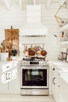 a stove top oven sitting inside of a kitchen next to white cabinets and counter tops