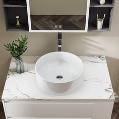 a white sink sitting on top of a counter next to a vase with flowers in it