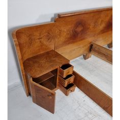 a wooden bed frame with drawers on the bottom and side panels open to reveal an extra storage compartment