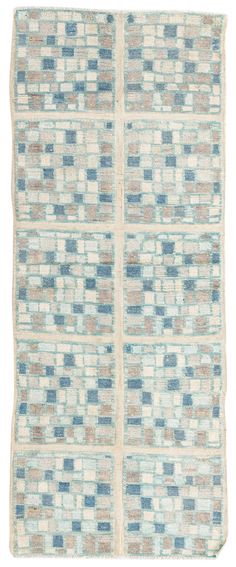 a blue and beige rug with squares on the bottom, in two different colors that appear to be made from wool