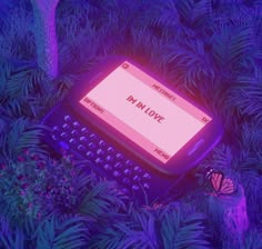 an old typewriter sitting in the middle of some trees with purple light on it