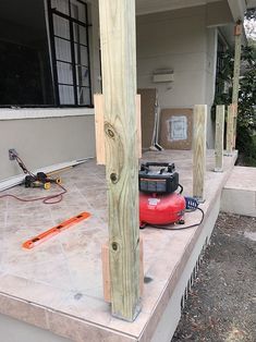 a red fire hydrant sitting on the side of a house next to a wooden post