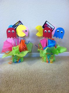 two colorful paper birds sitting on top of each other in front of a white wall