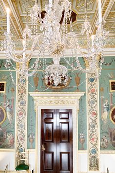 a chandelier hangs from the ceiling in an ornate room