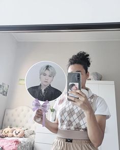 a woman taking a selfie in front of a mirror with a bow around her neck