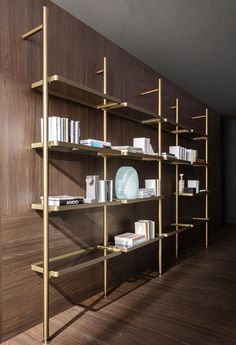 a wooden shelf filled with books on top of a hard wood floor next to a wall