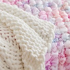 a blanket made out of white and pink yarn