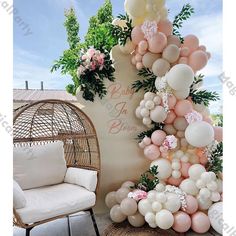 balloons and greenery decorate the backdrop for a baby shower