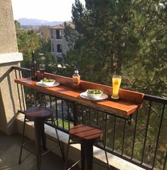 two plates of food and drinks on a balcony