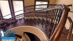 a spiral staircase with wrought iron railing and wood handrails in an upscale home