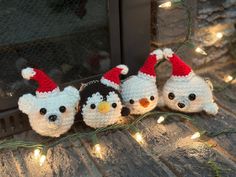 three crocheted penguin ornaments sitting on top of a wooden floor next to a fireplace