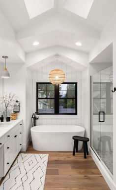 a large bathroom with a white bathtub and wooden floors