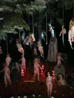 several people dressed up in costumes are hanging from strings with lights on them at night