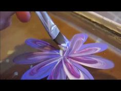 a purple flower being cut with a pair of scissors