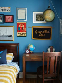 a bedroom with blue walls and pictures on the wall