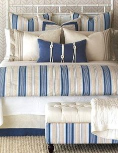 a bed with blue and white striped pillows