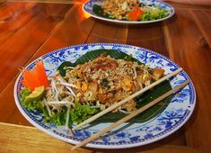 two plates filled with food on top of a wooden table