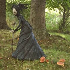 a statue of a witch in the woods