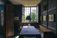 a long table with a lamp on it in the middle of a room next to a window