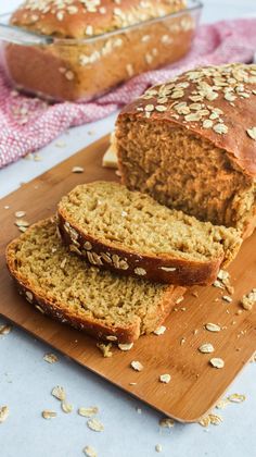 two loaves of bread sitting on top of a cutting board next to a loaf of bread