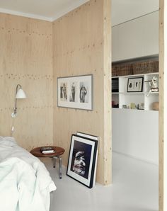 a bedroom with wood paneling and pictures on the wall, along with a small table