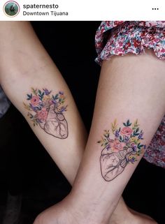 two people with matching tattoos on their arms, one has a heart and the other has flowers